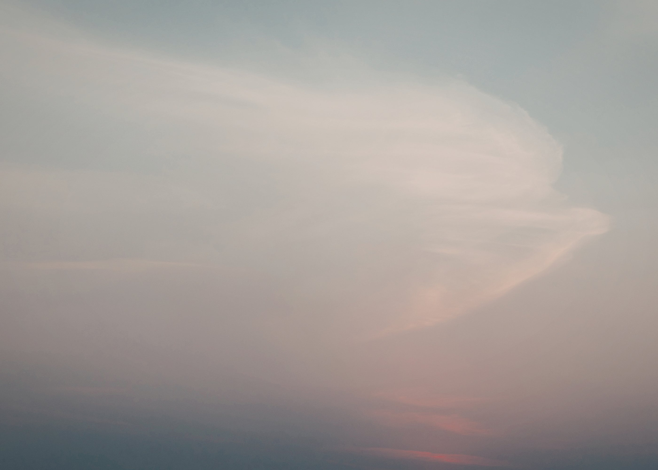 Hazy sky with soft pink and orange hues